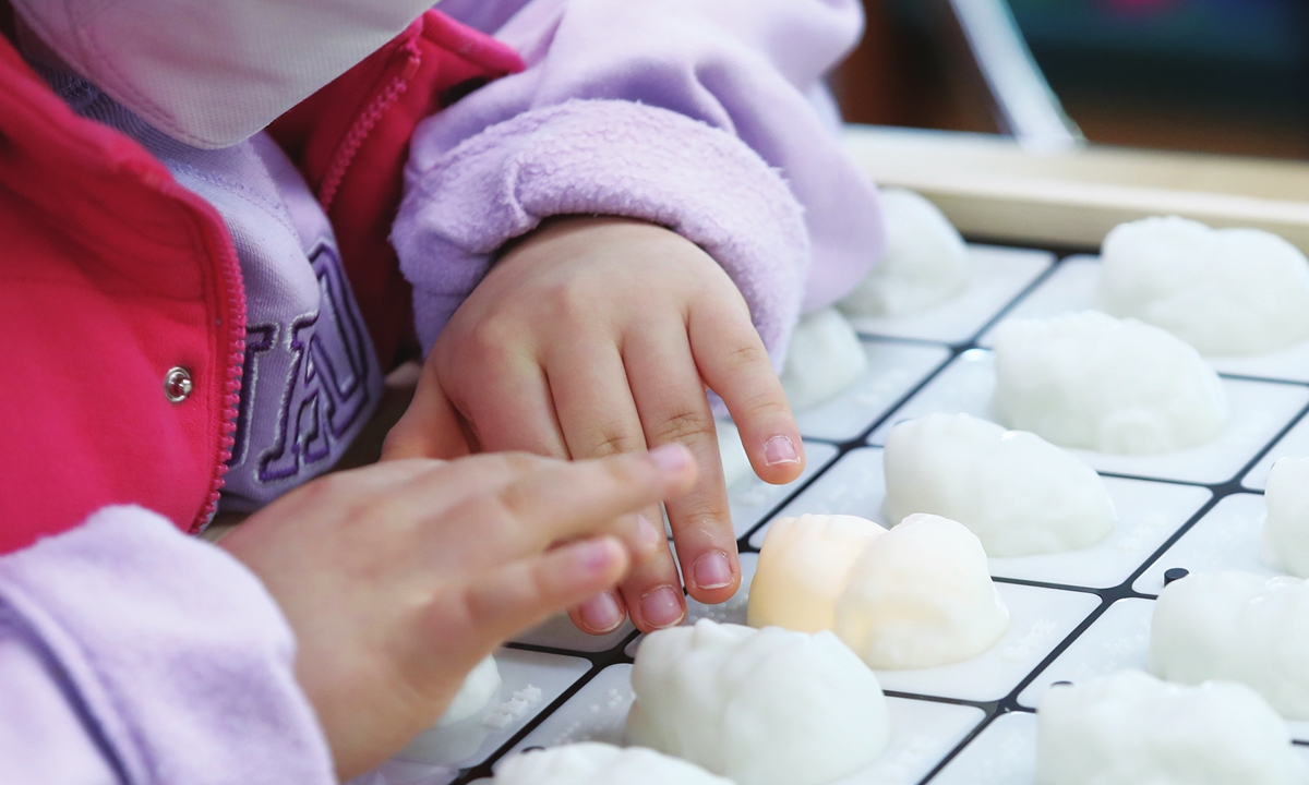 Graduates of the sixth grade of a primary school in Daegu, South Korea touching the 