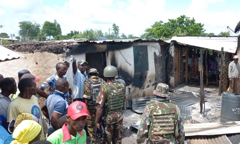 People gather around a house torched in an attack at a village in Lamu, Kenya, on Jan. 3, 2022. At least six villagers were killed on Monday in an attack by al-Shabab militants at a village in Kenya's coastal county of Lamu, local officials said.(Photo: Xinhua)