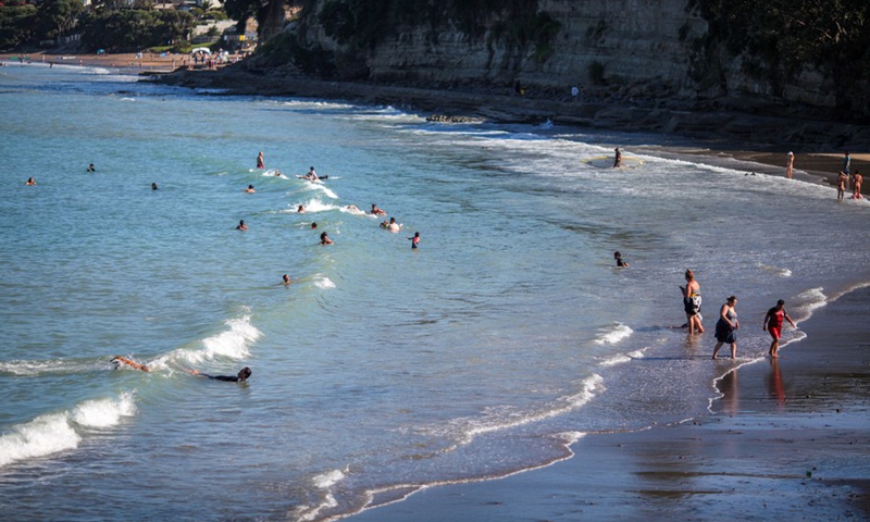 People enjoy leisure time on the beach in Auckland, New Zealand, on Jan. 4, 2022.(Photo: Xinhua)