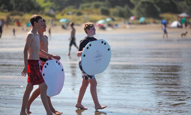 People enjoy leisure time on the beach in Auckland, New Zealand, Jan. 4, 2022.(Photo: Xinhua)