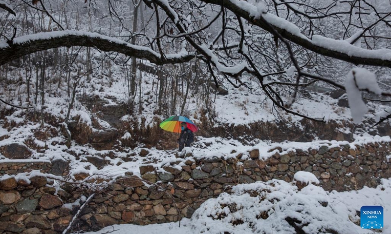 A man walks amid the season's first snowfall in Srinagar city, the summer capital of Indian-controlled Kashmir, Jan. 4, 2022. Srinagar city witnessed the season's first snowfall on Tuesday.(Photo: Xinhua)
