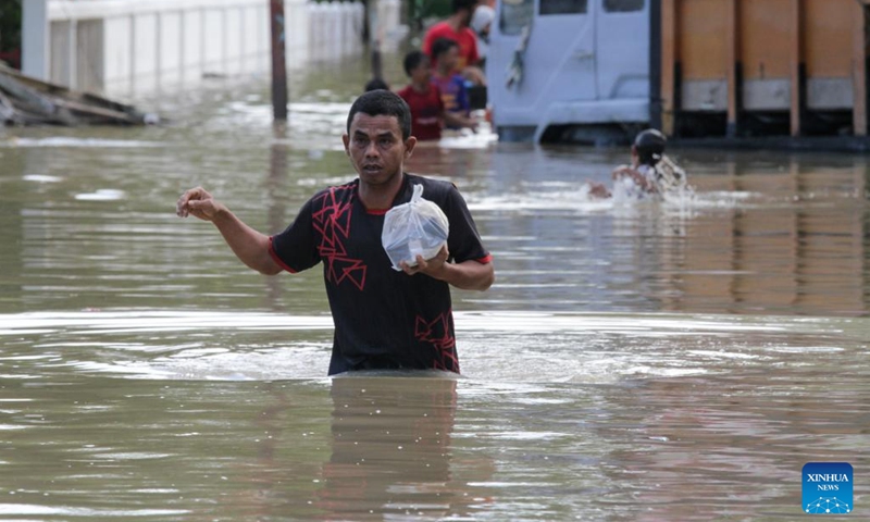 A man wades through floodwater in Lhoksukon of Aceh Province, Indonesia, Jan. 4, 2022. (Photo: Xinhua)