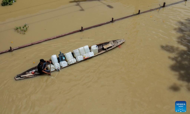 A man rows a boat through floodwater in Lhoksukon of Aceh Province, Indonesia, Jan. 4, 2022. (Photo: Xinhua)