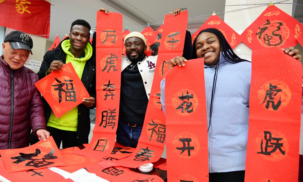Foreign students at Jiangsu University show their hand-written Spring Festival couplets and decorations with the Chinese character for fu (good fortune) in Zhenjiang, East China's Jiangsu Province, on January 5, 2022. Photo: VCG  