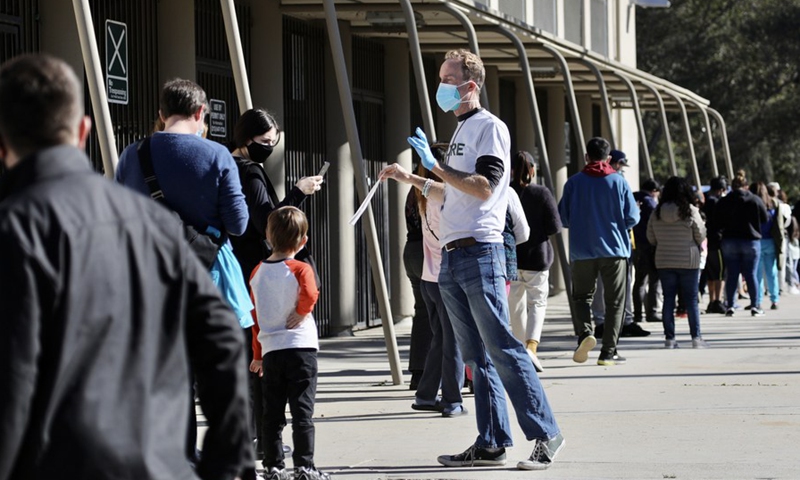 A health care worker reminds people waiting in line for COVID-19 testing at the Lincoln Heights Recreation Center testing site in Los Angeles, California, the United States, Jan. 2, 2022.(Photo: Xinhua)