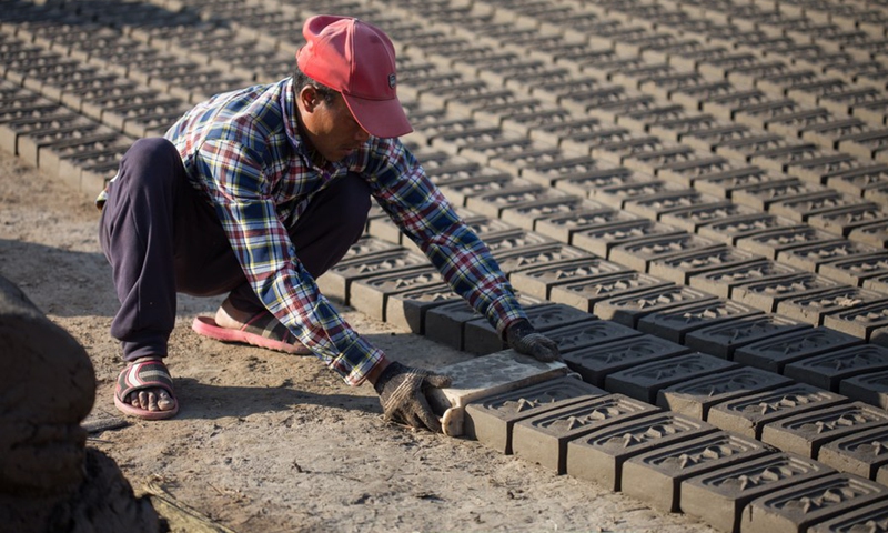 A worker makes bricks at a brick factory in Lalitpur, Nepal, on Jan. 4, 2022.(Photo: Xinhua)