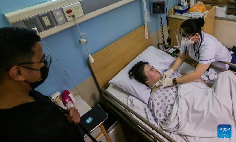 Li Jinxin, a 26-year-old Chinese woman, is attended to by her nurse Sherricka Mae Navalta (1st R) and neurologist Kim Alfred Inting (1st L) in the Medical City hospital in Pasig City, the Philippines on Dec. 13, 2021. Li Jinxin has found her dream of returning home come true after battling a devastating illness for almost two and a half years in the Philippines that nearly cost her life.(Photo: Xinhua)