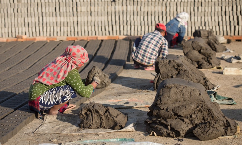 Workers make bricks at a brick factory in Lalitpur, Nepal, on Jan. 4, 2022.(Photo: Xinhua)