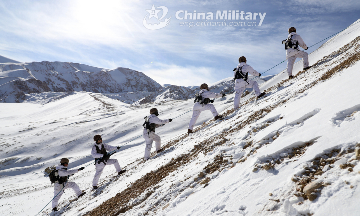 Soldiers assigned to a highland scout company with a regiment under the PLA Xinjiang Military Command practice climbing techniques as they cross over a steep hill during a reconnaissance and patrol mission on December 30, 2021. (eng.chinamil.com.cn/Photo by Han Qiang)