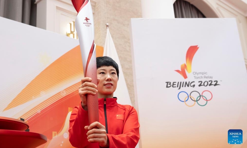 Short track speed skating Olympic champion Zhang Hui holds the torch during the Torch Exhibition Tour of Olympic Winter Games Beijing 2022 in Harbin, northeast China's Heilongjiang Province, Jan. 5, 2022.Photo:Xinhua