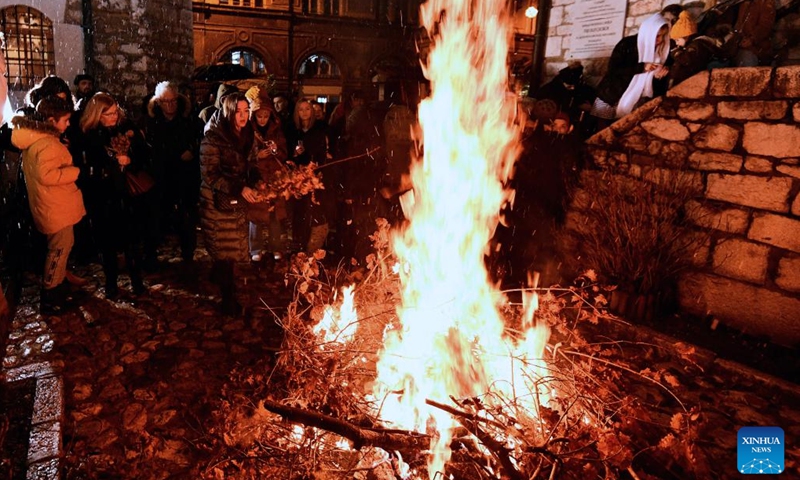 People burn dried oak branches during a traditional ceremony in front of the Old Orthodox Church to celebrate Orthodox Christmas Eve in Sarajevo, Bosnia and Herzegovina, Jan. 6, 2022.Photo:Xinhua