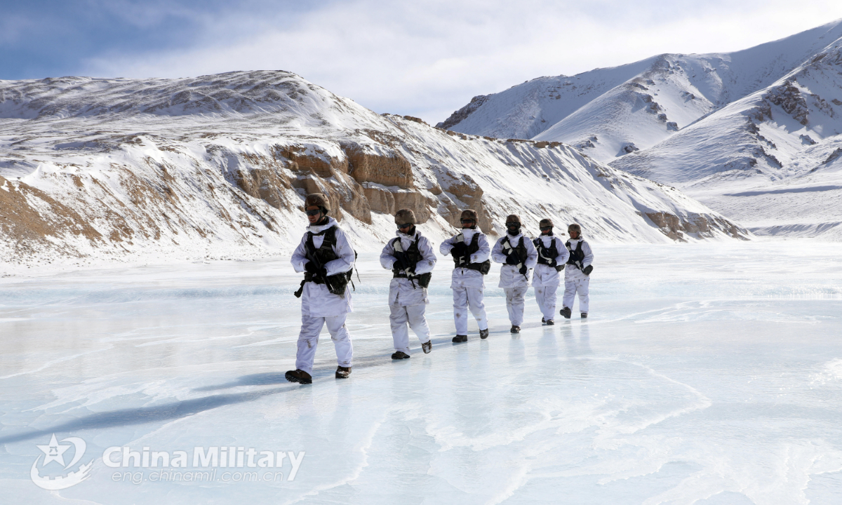 Soldiers assigned to a highland scout company with a regiment under the PLA Xinjiang Military Command patrol on frozen water during a highland tactical reconnaissance training exercise on December 30, 2021. (eng.chinamil.com.cn/Photo by Han Qiang) 