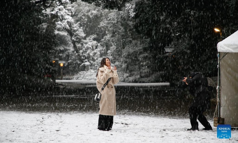 A visitor poses for a photo in snow at Meiji Jingu in Tokyo, Japan, Jan. 6, 2022.(Photo: Xinhua)