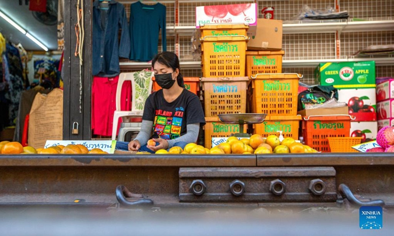 A vendor is seen at Maeklong Railway Market in Samut Songkhram Province, Thailand, Jan. 5, 2022. In Maeklong Railway Market, built along a railway track, a compromise is reached between vendors and passing commuter trains. When the rail track is clear, stall owners can set up stalls at will. Before the COVID-19 pandemic, the market had attracted many tourists. (Photo: Xinhua)