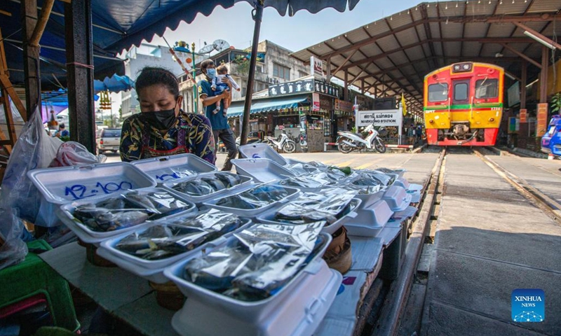 A vendor is seen at Maeklong Railway Market in Samut Songkhram Province, Thailand, Jan. 5, 2022. In Maeklong Railway Market, built along a railway track, a compromise is reached between vendors and passing commuter trains. When the rail track is clear, stall owners can set up stalls at will. Before the COVID-19 pandemic, the market had attracted many tourists.(Photo: Xinhua)