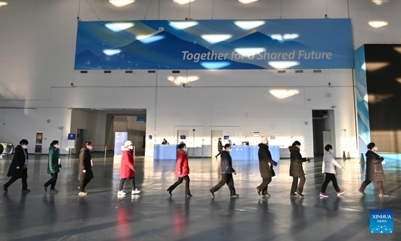 Staff walk in a line at the Main Media Center for the 2022 Olympic and Paralympic Winter Games in Beijing, capital of China, Jan. 10, 2022. (Xinhua/He Changshan)