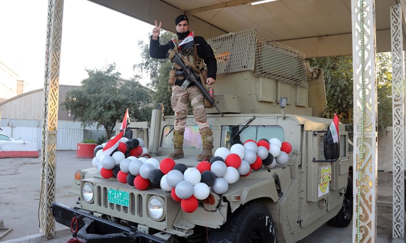 An Iraqi soldier waves the victory sign while standing on a military vehicle decorated with balloons on the occasion of Iraqi Army Day in Baghdad, Iraq, on Jan. 6, 2022.(Photo: Xinhua)