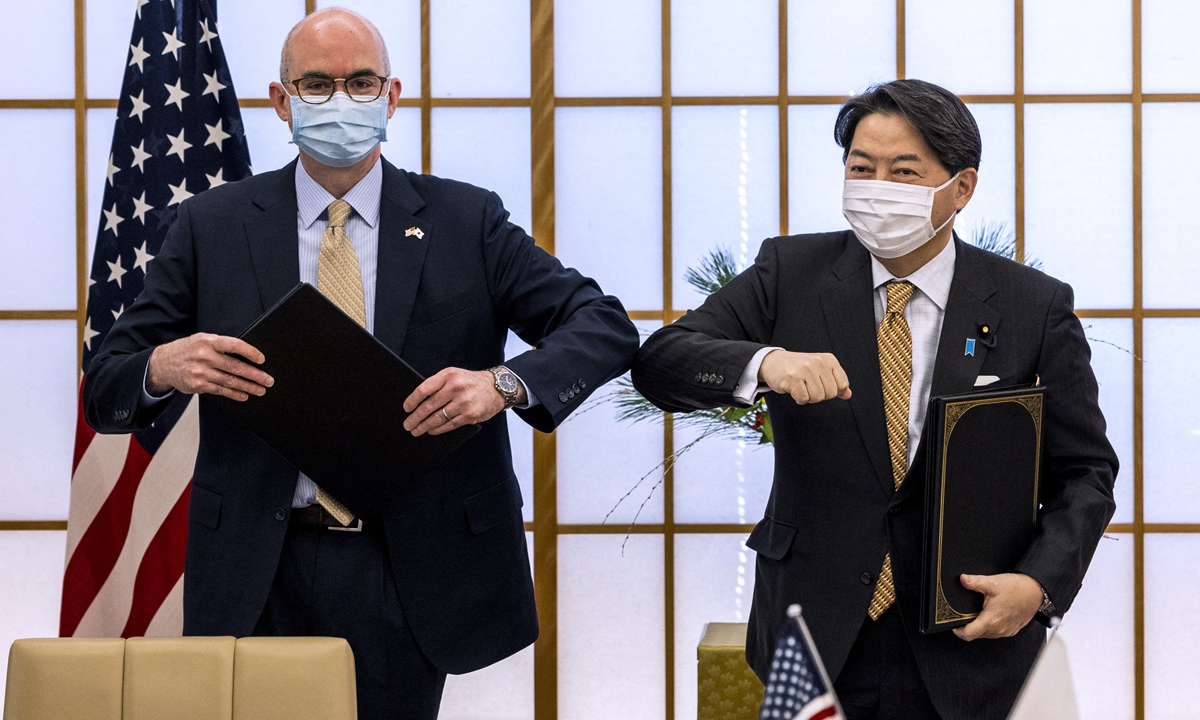 Japan's Foreign Minister Yoshimasa Hayashi (right) and Raymond Greene, Charge d'Affairs ad interim of the US embassy in Japan, bump elbows after signing a New Special Measures Agreement and Japan-US Joint Research in Tokyo on January 7, 2022. 