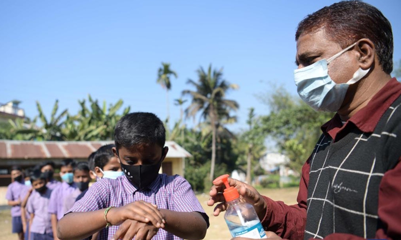 Students sanitize their hands before entering classroom at a school in Agartala, the capital city of India's northeastern state of Tripura, Jan. 8, 2022.Photo:Xinhua