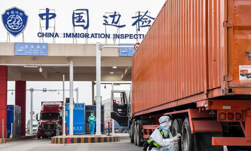 A police officer of immigration inspection checkpoint checks a truck at Dongxing port in Dongxing, south China's Guangxi Zhuang Autonomous Region, Jan. 8, 2022.Photo:Xinhua