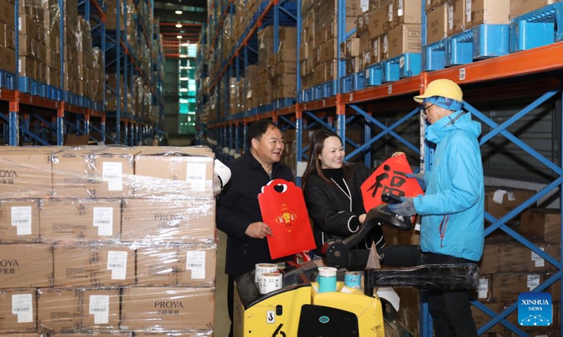 A labour union staff member delivers Chinese character Fu, which means good fortune, to a worker at a cosmetics company in Wuxing District of Huzhou, east China's Zhejiang Province, Jan. 8, 2022.Photo:Xinhua