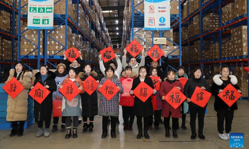 Workers pose for group photos with Chinese character Fu, which means good fortune, at a cosmetics company in Wuxing District of Huzhou, east China's Zhejiang Province, Jan. 8, 2022.Photo:Xinhua