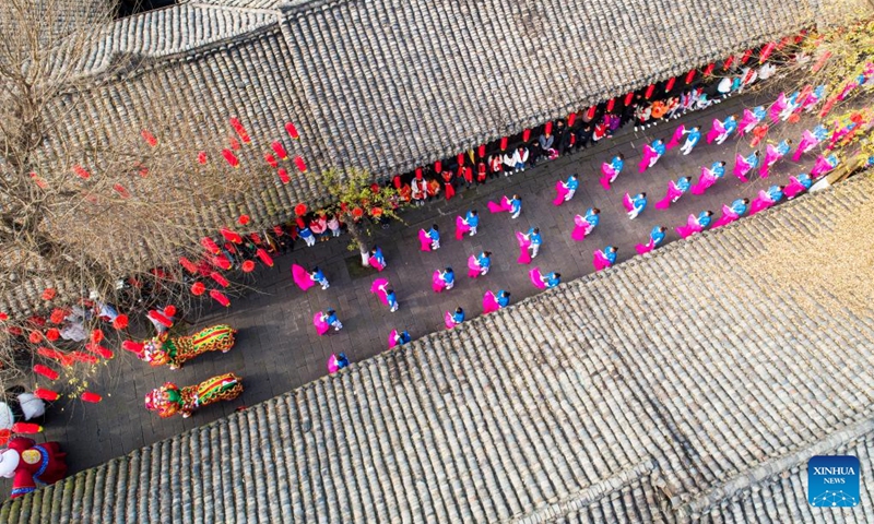 Aerial photo taken on Jan. 8, 2022 shows people performing silk fan dancing at Langzhong ancient town in southwest China's Sichuan Province.Photo:Xinhua