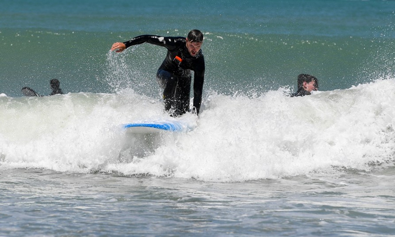 People surf at Lyall Bay of Wellington, capital of New Zealand, Jan. 8, 2022.Photo:Xinhua