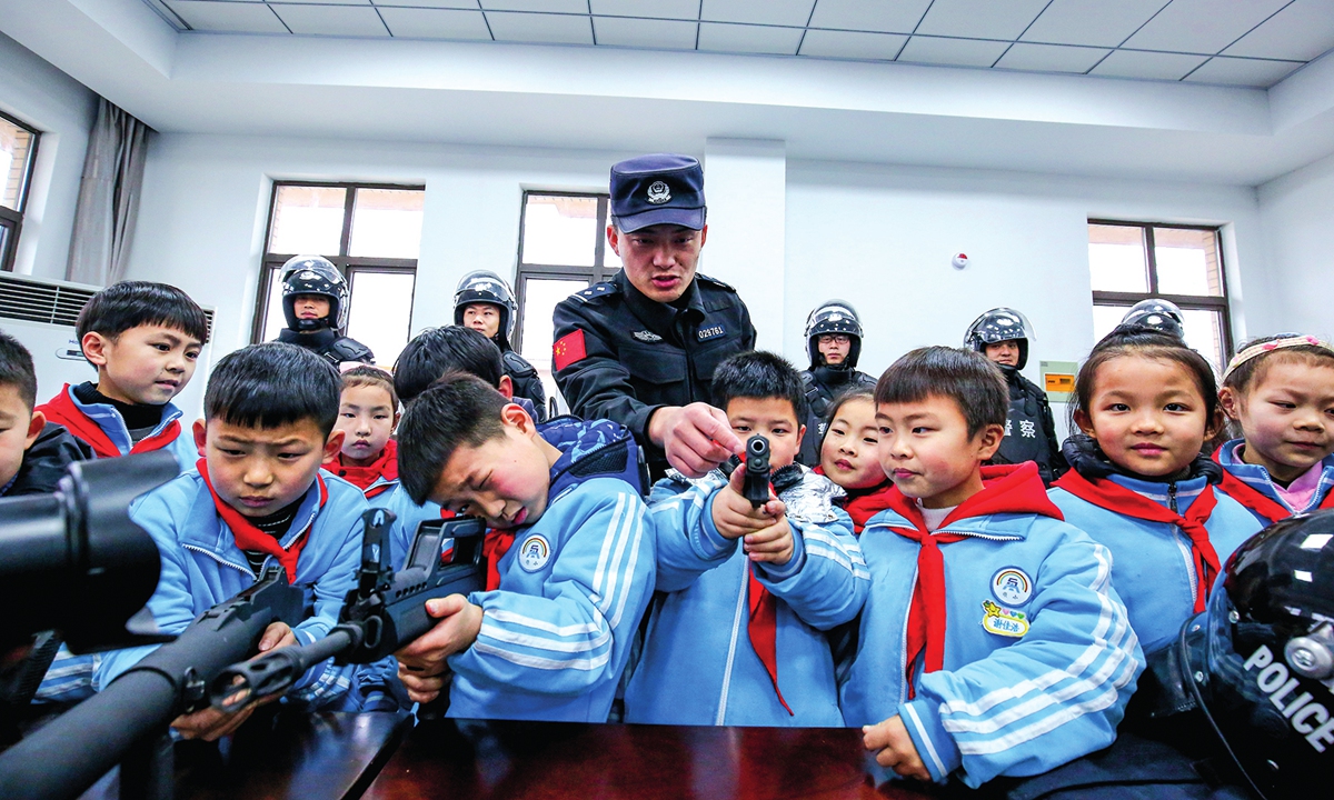 Police officers show children their weapons and police equipment in an activity to celebrate the Chinese People's Police Day in Tongling, East China's Anhui Province on January 7, 2022.