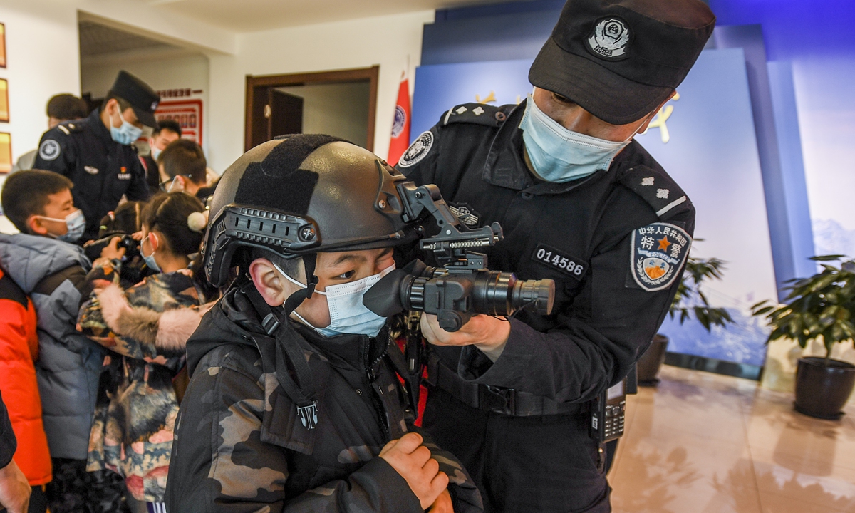 Children try special police equipment at the training base of the special police detachment of the public security bureau in Urumqi, capital city of Northwest China's Xinjiang Uygur Autonomous Region, on January 9, 2022. One day ahead of the second Police Day in China, which falls on January 10, more than 20 children visited the base. Photo: VCG