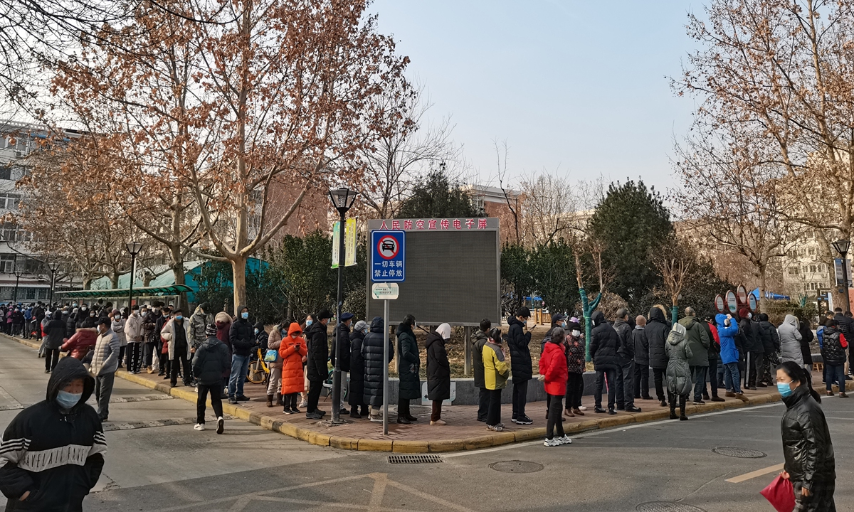 Residents line up to undergo nucleic acid testing in a residential compound in Tianjin's Nankai district on January 9, 2022. Photo: VCG