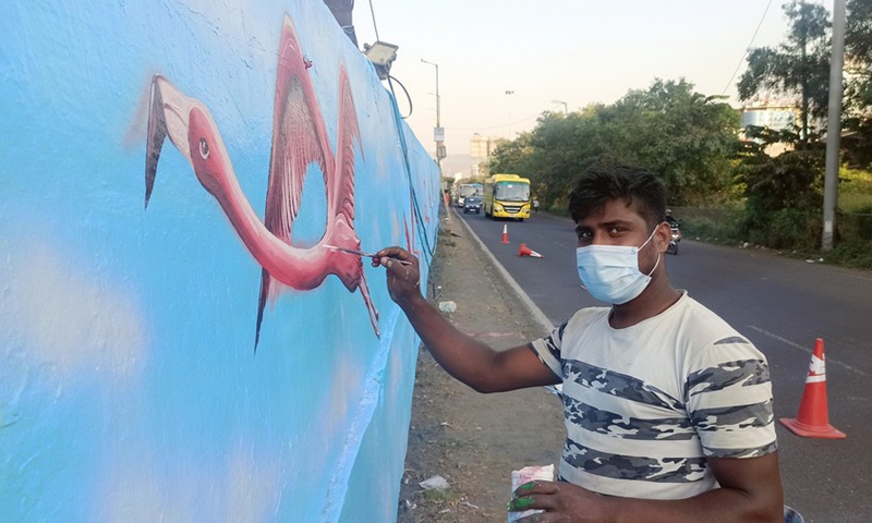 An artist gives a final touch to his flamingo artwork on the wall in Mumbai, India, Jan. 10, 2022.(Photo: Xinhua)