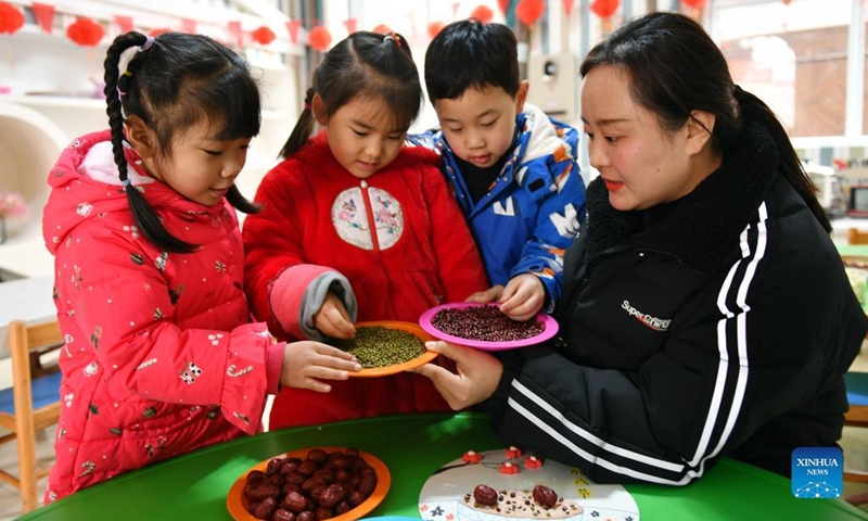 A teacher teaches children to identify Laba porridge ingredients at a kindergarten in Zigui County, central China's Hubei Province, Jan. 10, 2022. The Laba Festival, literally the eighth day of the 12th lunar month, is considered a prelude to the Spring Festival, or Chinese Lunar New Year. It is customary to eat Laba porridge on this day(Photo: Xinhua)