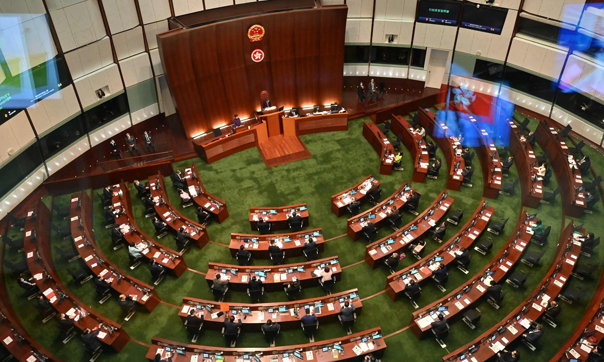 Hong Kong's Chief Executive Carrie Lam (left) speaks during the first session of the 7th Legislative Council (LegCo) in Hong Kong on January 12, 2022. The Chinese national emblem is displayed above Hong Kong's bauhinia insignia in the main chamber, underscoring the constitutional status of the HKSAR as one of China's regions. Photo: VCG