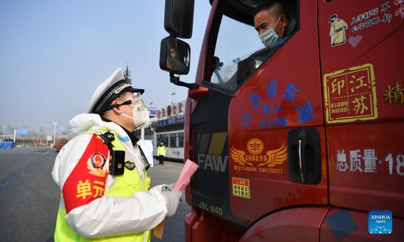 A policeman talks with a driver at a tollgate in Xi'an, capital of northwest China's Shaanxi Province, Jan. 10, 2022. Monday marks the second Chinese People's Police Day. It falls every Jan. 10, corresponding with the country's emergency call number of 110. Policemen in Xi'an stick to their posts on the day to secure the COVID-19 epidemic prevention and control.(Photo: Xinhua)