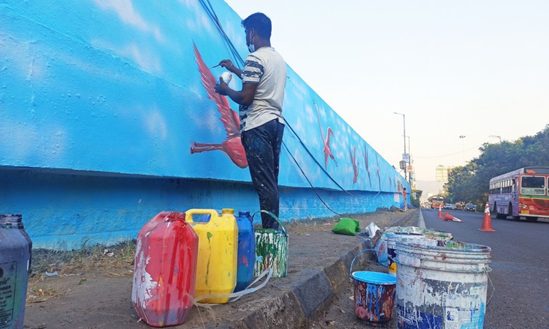 An artist gives a final touch to his flamingo artwork on the wall in Mumbai, India, Jan. 10, 2022.(Photo: Xinhua)