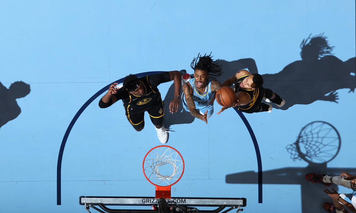 Ja Morant (center) of the Memphis Grizzlies shoots against the Golden State Warriors on January 11, 2022 in Memphis, Tennessee. Photo: VCG