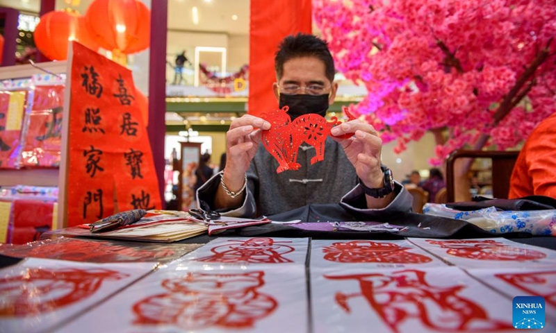An paper-cut artist shows his work at the Pavilion Paper Art Garden in Kuala Lumpur, Malaysia, Jan. 11, 2022. The Pavilion Paper Art Garden, with splendid traditional Chinese art of paper cutting works, was set in celebrations of the upcoming Chinese New Year(Photo: Xinhua)