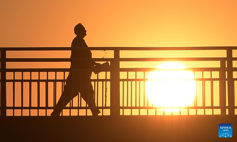 Photo taken on Jan. 11, 2022 shows the silhouette of a man walking on a bridge during sunset in Islamabad, capital of Pakistan(Photo: Xinhua)