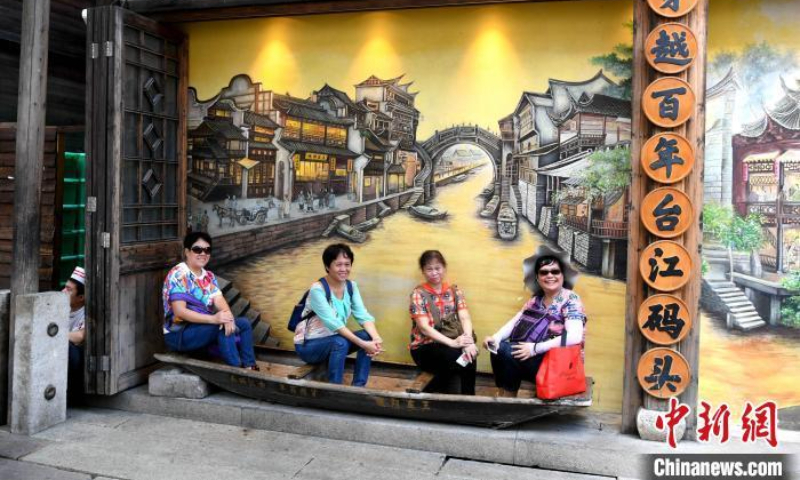 游客在中国东南部福建省福州的上下杭传统街区拍照。  （图片：中新社/王东明）