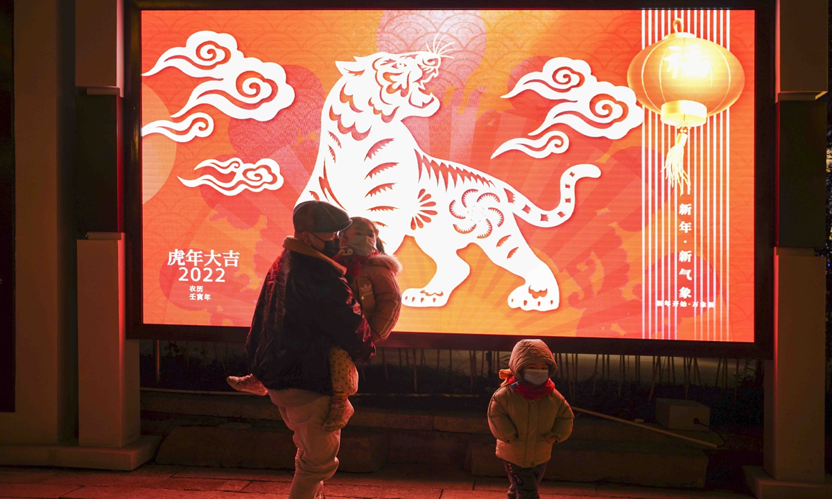 Residents walk past an LED panel featuring a tiger in Wenzhou, East China's Zhejiang Province on January 11, 2022. As the Spring Festival of the Year of the Tiger approaches, the streets in the city are hung with festive decorations. Photo: VCG