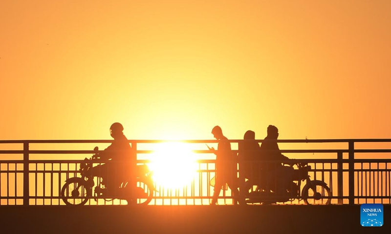 Photo taken on Jan. 11, 2022 shows the silhouette of people on a bridge during sunset in Islamabad, capital of Pakistan.(Photo: Xinhua)