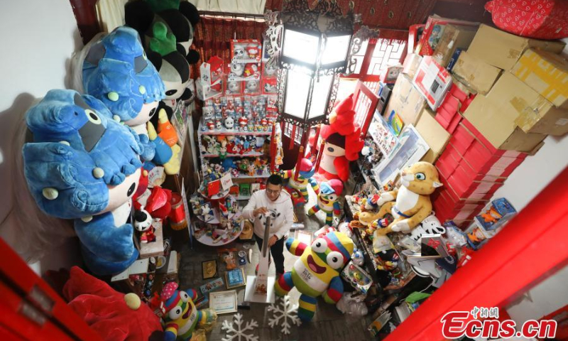 Zhang Wenquan arranges Olympic souvenirs, January 12, 2022, Beijing. (Photo: China News Service/Zhao Juan)