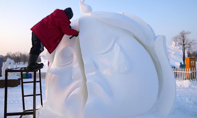 A contestant carves a snow sculpture during the 28th Harbin snow sculpture competition at the Sun Island International Snow Sculpture Art Exposition in Harbin, northeast China's Heilongjiang Province, Jan. 12, 2022. The competition kicked off on Tuesday. Nearly 60 contestants of 19 teams from all over the country participated in the game.(Photo: Xinhua)