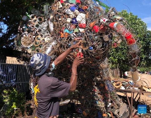 Johnson Zuze, a mixed media artist, works on his latest piece of art made from recycled materials in Chitungwiza, Zimbabwe, on Dec. 29, 2021.(Photo: Xinhua)