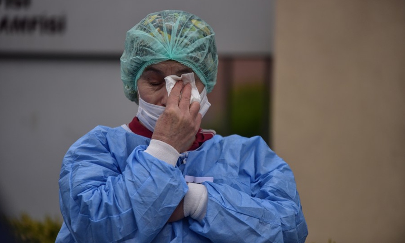 A Turkish health worker joins in a moment of silence in front of a hospital building in Istanbul,Turkey on April 2, 2020.(Photo: Xinhua)
