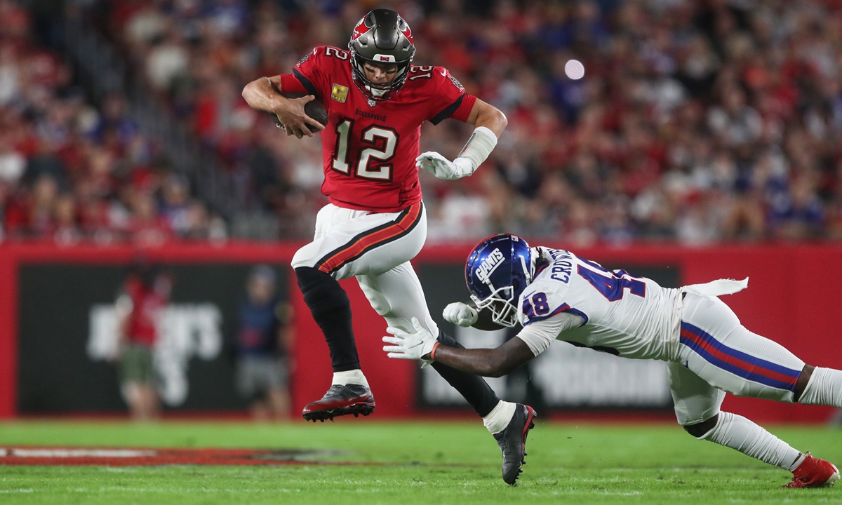 Tampa Bay Buccaneers quarterback Tom Brady (left) scrambles for yardage and a first down during the NFL game against the New York Giants on November 22, 2021 in Tampa, Florida. Photo: VCG