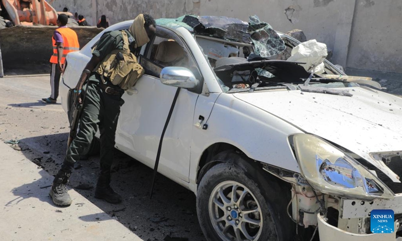 A security member checks a car at the scene of a suicide car bombing attack in Mogadishu, Somalia, on Jan. 12, 2022. At least ten people including five soldiers were killed and nine others wounded in a suicide car bombing in the Somali capital, Mogadishu on Wednesday, officials said.(Photo: Xinhua)