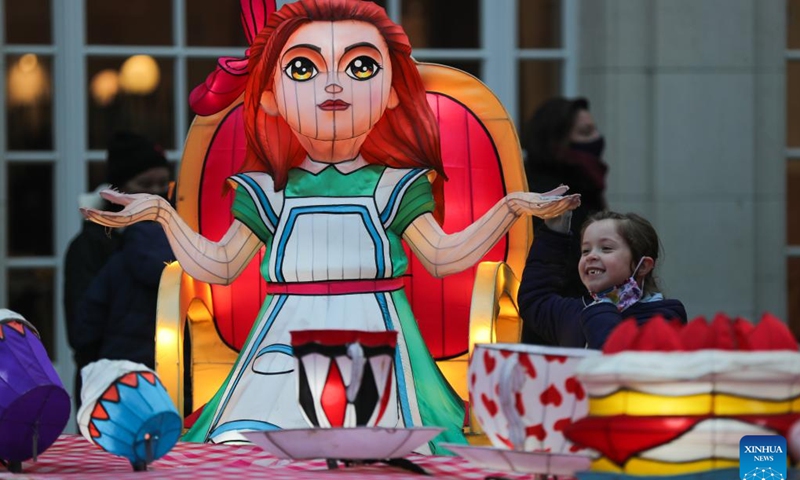 A kid poses for photos with light installations during the sixth edition of China light festival themed Alice in Wonderland at the Antwerp Zoo in Antwerp, Belgium, Jan. 12, 2022(Photo: Xinhua)