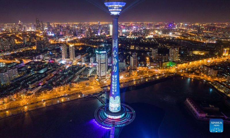 Aerial photo shows a landmark lit up to pay tribute to people making efforts to fight against the recent resurgence of COVID-19 pandemic in north China's Tianjin, Jan. 13, 2022.Photo:Xinhua
